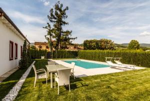 een achtertuin met een tafel en stoelen en een zwembad bij Podere Villa Olmo in Pistoia