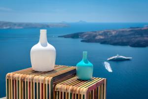 deux vases assis au-dessus d'une table près de l'eau dans l'établissement Modernity Suites, à Fira