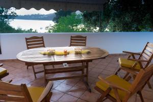 una mesa de madera y sillas en un patio en Villa Mitsa, en Kolios