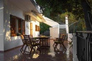 un patio con sillas y una mesa en un porche en Villa Mitsa, en Kolios