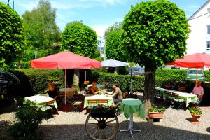 un grupo de personas sentadas en mesas en un jardín en Hotel Löwen, en Kirchzarten