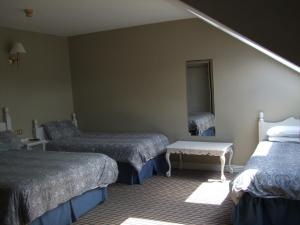 um quarto de hotel com duas camas e um espelho em Harmony Inn - Glena House em Killarney