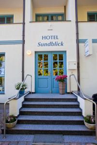 um edifício com uma porta azul e escadas em frente em Hotel Sundblick em Altefähr