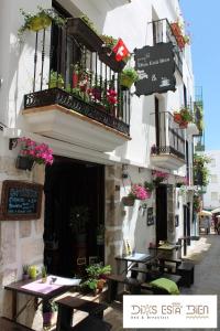 ein Gebäude mit Tischen und Balkonen auf einer Straße in der Unterkunft Dios Esta Bien in Peñíscola