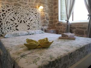 een slaapkamer met een groot bed en een stenen muur bij Apartments Jasmina in Korčula