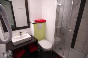 La salle de bains est pourvue d'un lavabo, de toilettes et d'une douche. dans l'établissement Enzo Hotels Pont-a-Mousson by Kyriad Direct, à Pont-à-Mousson