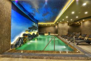 a pool in a hotel room with a painting on the wall at Marigold Thermal & Spa Hotel Bursa in Bursa