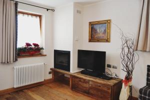 sala de estar con TV de pantalla plana sobre una mesa de madera en Maison Carrel Elegant 8, en Breuil-Cervinia