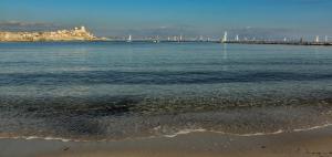 een waterlichaam met een strand en een pier bij Hôtel Josse in Antibes