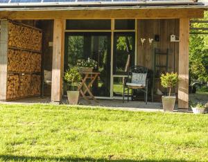 een veranda van een huis met een stoel en een tafel bij het Atelier in Eext