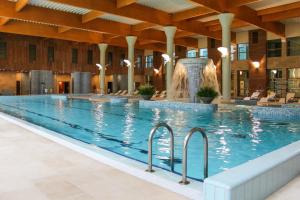 ein großer Pool mit Brunnen in einem Gebäude in der Unterkunft Medical SPA "Eglės sanatorija" Birštonas in Birštonas