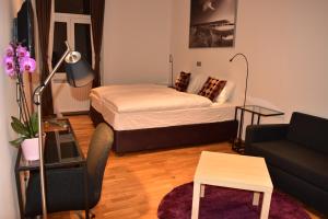 B&B Cool Centre Zagreb في زغرب: غرفة صغيرة بها سرير وأريكة