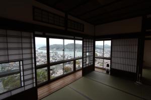 Cette chambre dispose de fenêtres et offre une vue sur la ville. dans l'établissement Onomichi Guest House Miharashi-tei, à Onomichi