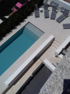 una terrazza con vista sulla piscina. di Hotel Nettuno a Cala Gonone