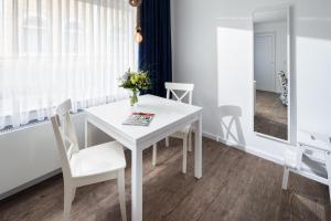 una sala da pranzo bianca con tavolo e sedie bianchi di Ferienhaus Papenfuß a Norderney