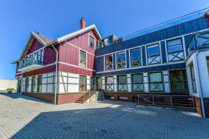 een groot rood-wit gebouw met veel ramen bij Nida Vėtrungių 3 , apartamentai in Nida