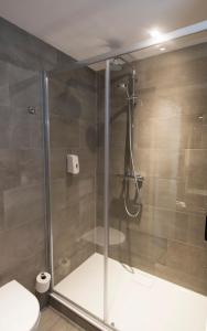 a shower with a glass door in a bathroom at Hotel De Zoete Inval Haarlemmerliede in Haarlem