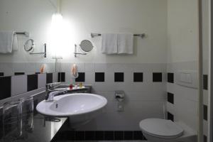 een witte badkamer met een wastafel en een toilet bij IntercityHotel Bremen in Bremen