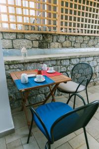 una mesa de madera y sillas en un patio en Maistros Kardamyli Apartments, en Kardhamili