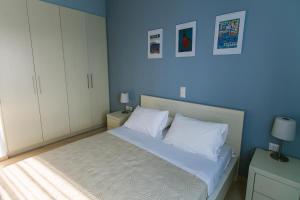 1 dormitorio con 1 cama con paredes azules y armarios blancos en Maistros Kardamyli Apartments, en Kardhamili