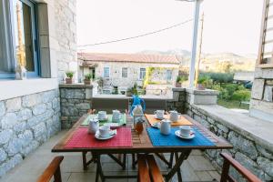 una mesa de madera con tazas y platillos en el patio en Maistros Kardamyli Apartments, en Kardhamili