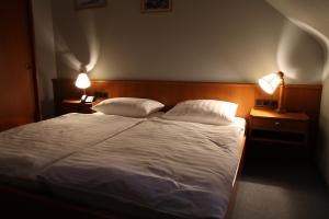 a bedroom with a large bed with two lights on it at Hotel Sieweburen in Luxembourg