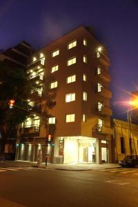 ein hohes Gebäude in der Nacht auf einer Stadtstraße in der Unterkunft Lecer Apart in Buenos Aires