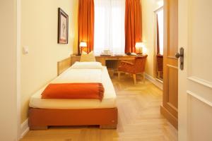 a bedroom with a bed and a desk in a room at Hotel Villa Florentina in Frankfurt/Main