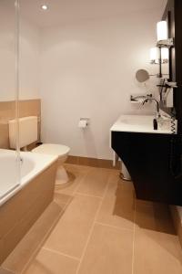 a bathroom with a sink and a tub and a toilet at Hotel Villa Florentina in Frankfurt/Main