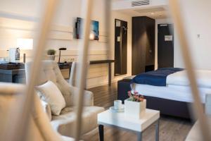 une chambre d'hôtel avec un lit et un salon dans l'établissement Hotel Novum, à Hinte