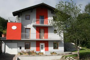 ein rotes und weißes Haus mit einem Balkon in der Unterkunft Birnhornblick in Leogang