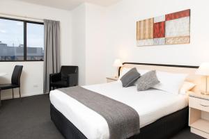 Adelaide Riviera Hotel في أديلايد: غرفه فندقيه بسرير ونافذه