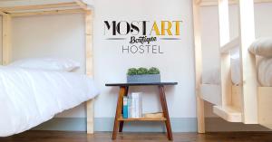 レイリアにあるMost Art Boutique Hostelのゲスト用ベッドルーム(ベッド1台、テーブル、本付)