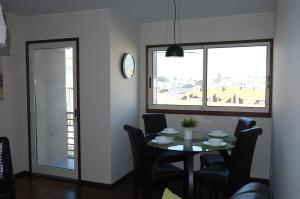 d'une salle à manger avec une table, des chaises et une fenêtre. dans l'établissement Porto 2 Bedroom Beach Apartment, à Matosinhos