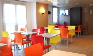 un comedor con mesas y sillas coloridas en Premiere Classe Niort Est - Chauray, en Niort