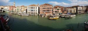 um grupo de barcos em um rio com edifícios em Antica Locanda Sturion Residenza d'Epoca em Veneza