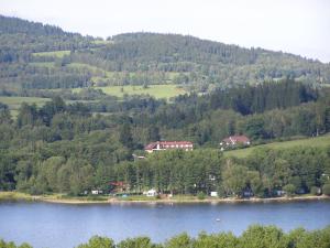 een uitzicht op een meer met huizen en bomen bij Penzion u Kukačků in Horní Planá