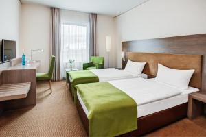 a hotel room with a large bed and a desk at IntercityHotel Mainz in Mainz