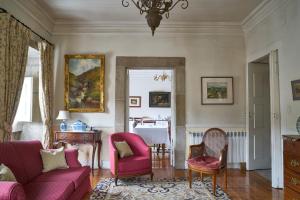 a living room with a pink couch and chairs at Casa De Fatauncos in Vouzela