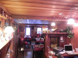 a restaurant with wooden walls and tables and chairs at Le Vieux Rascard Chambres d'Hotes in Champoluc