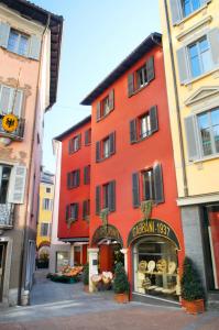 um edifício vermelho com uma padaria em frente em Hotel Gabbani em Lugano