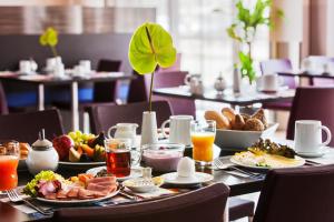 een tafel met ontbijtproducten en drankjes erop bij IntercityHotel Mannheim in Mannheim