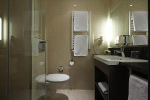 een badkamer met een toilet, een wastafel en een douche bij IntercityHotel Mannheim in Mannheim