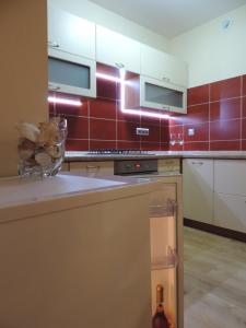 una cocina con azulejos rojos en la pared en Apartament Violet, en Krosno