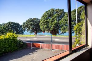 een raam met uitzicht op een parkeerplaats bij Bennetts Thermal Motor Inn in Tauranga