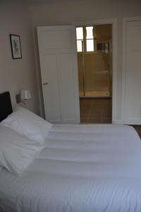 een slaapkamer met een wit bed en een badkamer bij Appartement Chaussee du Sillon in Saint-Malo