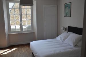 een slaapkamer met een wit bed en een raam bij Appartement Chaussee du Sillon in Saint-Malo