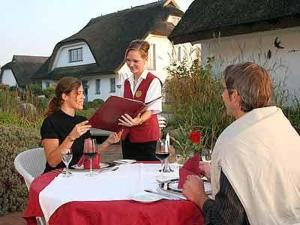 un grupo de personas sentadas alrededor de una mesa en Landhotel Kastanienallee Putbus, en Putbus