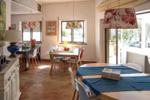 een keuken en eetkamer met een tafel en stoelen bij Moby Dick Lodge in Malveira da Serra