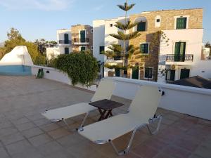 two chairs and a table on a roof with buildings at Archipelagos in Naxos Chora